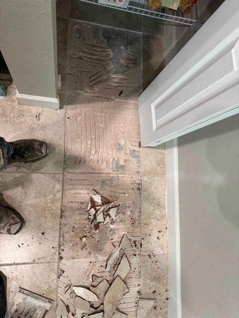 Bio-Cleaning Services crew removing existing tile flooring during property renovation — Central Florida.