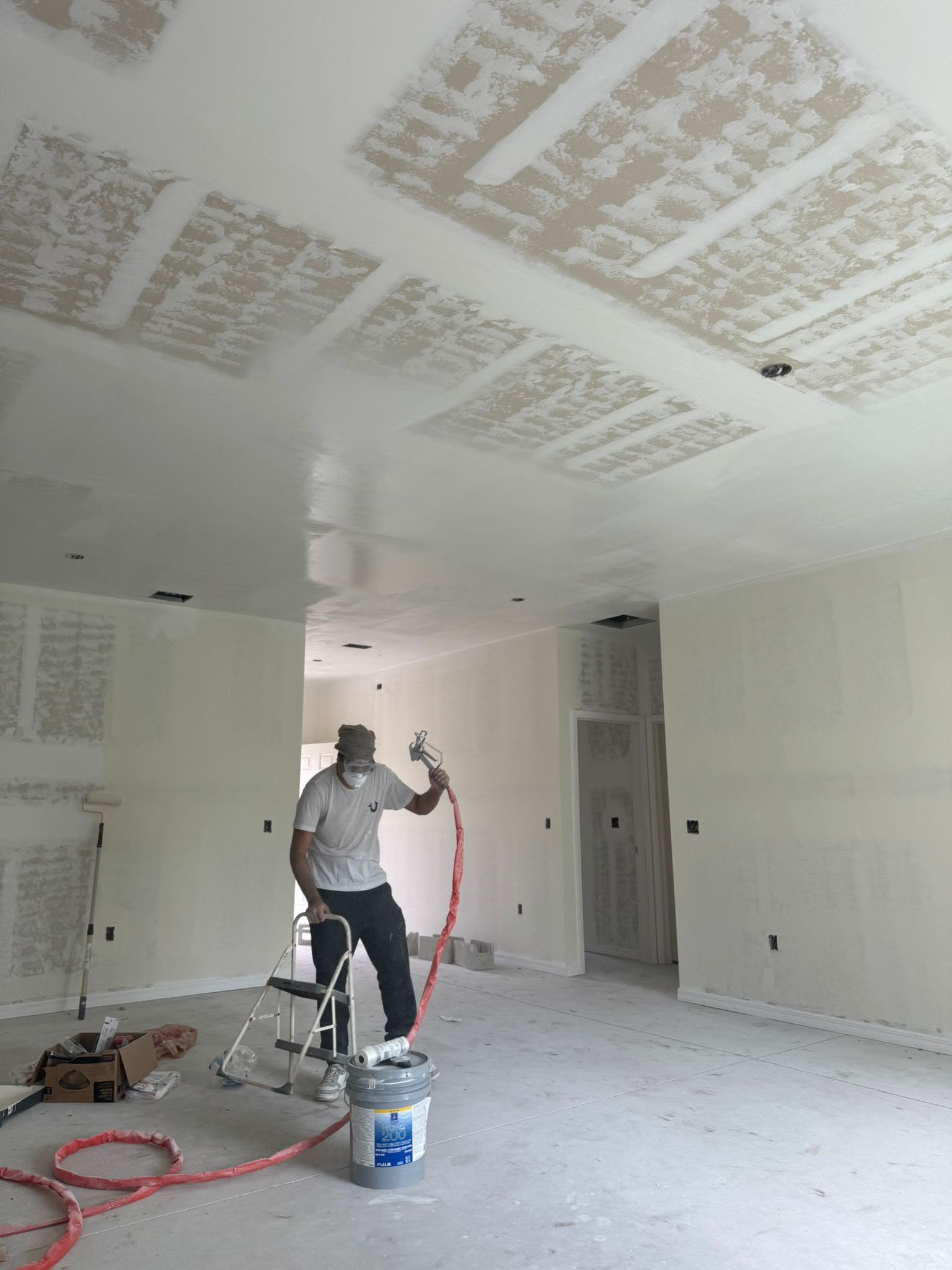 Bio-Cleaning Services crew performing interior drywall finishing and spray painting — Central Florida.